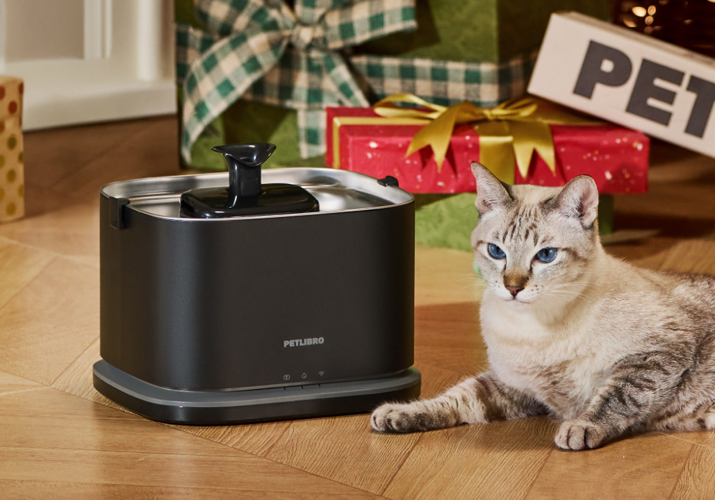 Petlibro PETLIBRO fontaine à eau noire pour animal de compagnie, chat allongé à côté; mention distributeur automatique de nourriture et bac à litière
