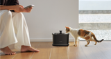 Petlibro PETLIBRO animal de compagnie: chat boit à la fontaine à eau noire; mention distributeur automatique de nourriture et bac à litière.